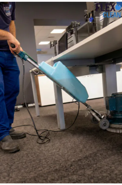 Técnico da Flex Clean higienizando carpete em escritório com equipamento profissional