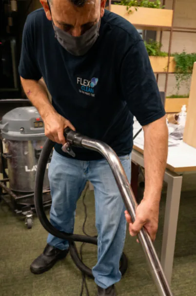 Técnico da Flex Clean limpando carpete corporativo com equipamento profissional