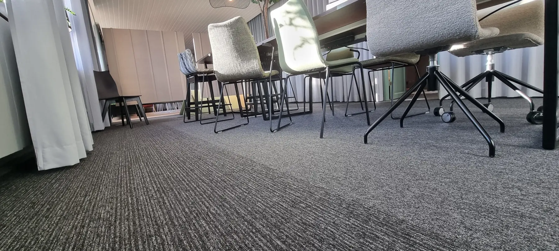 Fileira de cadeiras em ambiente corporativo sobre piso de carpete