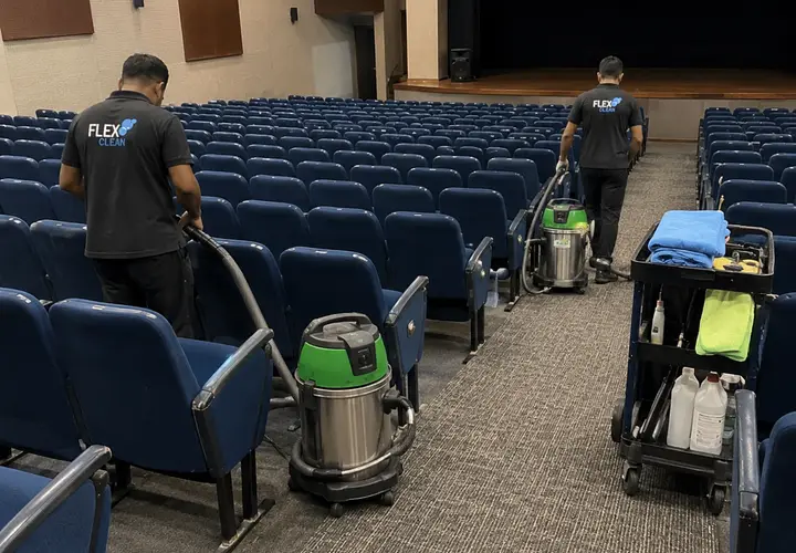 Dois técnicos da Flex Clean higienizando poltronas de auditório corporativo