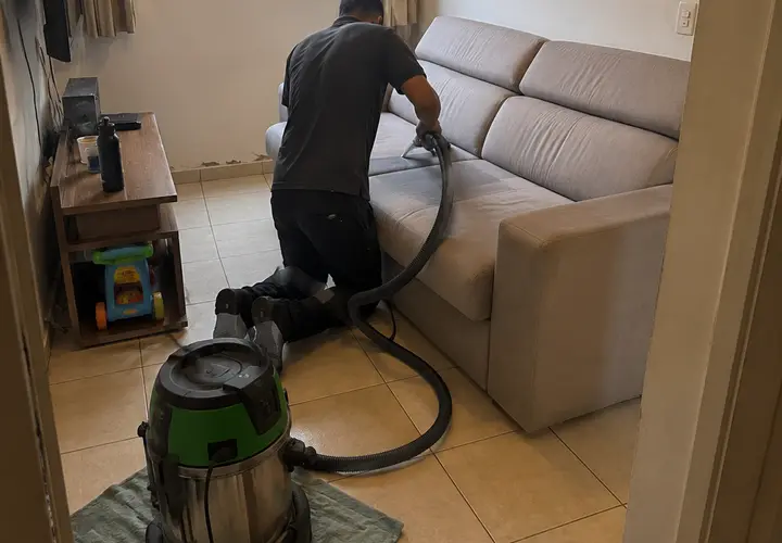 Técnico da Flex Clean higienizando sofá em atendimento residencial