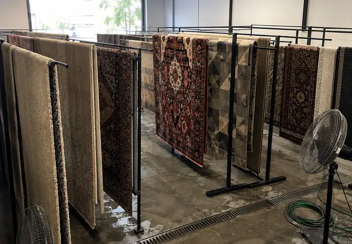 Tapetes pendurados no varal de secagem da lavanderia da Flex Clean