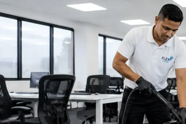 Técnico da Flex Clean higienizando cadeiras de escritório com extratora em um open space