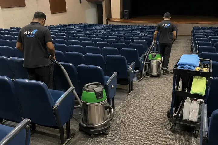 Dois técnicos da Flex Clean higienizando as poltronas de um auditório corporativo