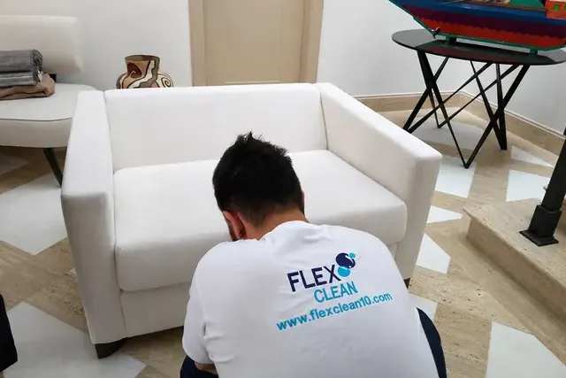 Profissional da Flex Clean higienizando uma poltrona branca para eliminar o mau odor