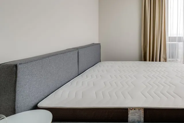 Colchão sem roupa de cama em um quarto claro, antes da higienização
