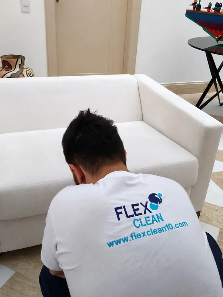 Profissional uniformizado da Flex Clean higienizando poltrona branca