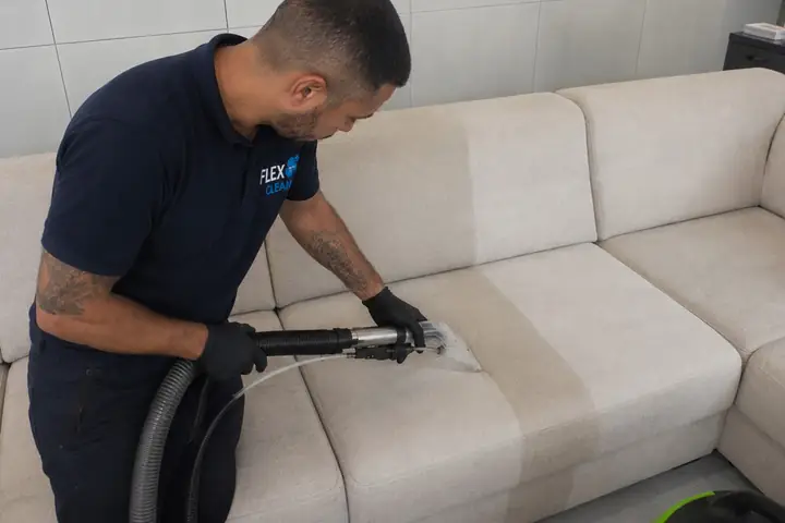 Técnico da Flex Clean removendo o encardido de um sofá claro com extratora