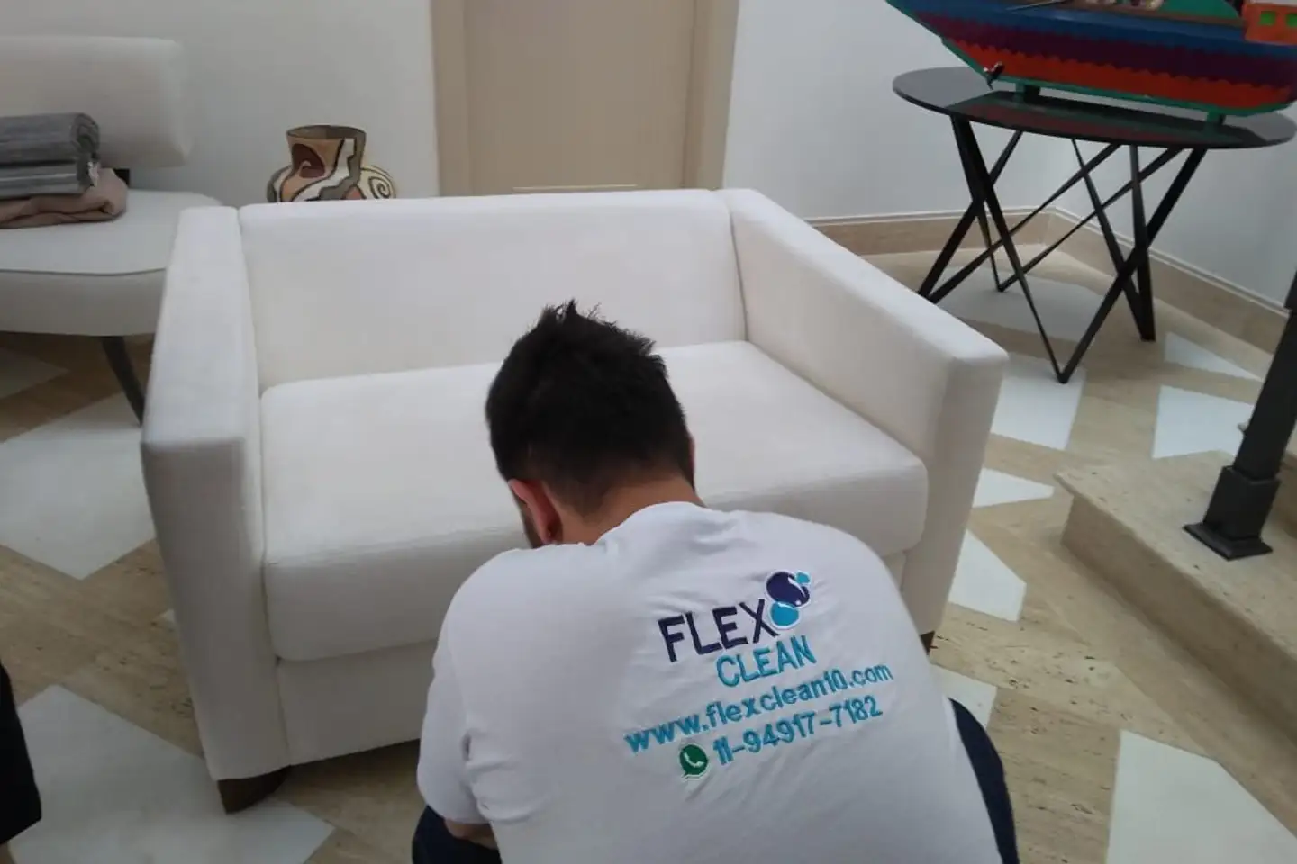 Profissional da Flex Clean higienizando uma poltrona na casa do cliente
