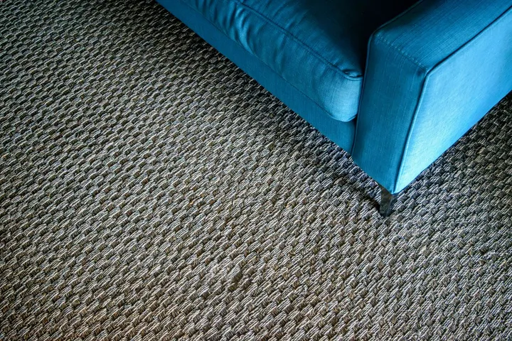 Tapete de sisal de fibra natural sob um sofá na sala