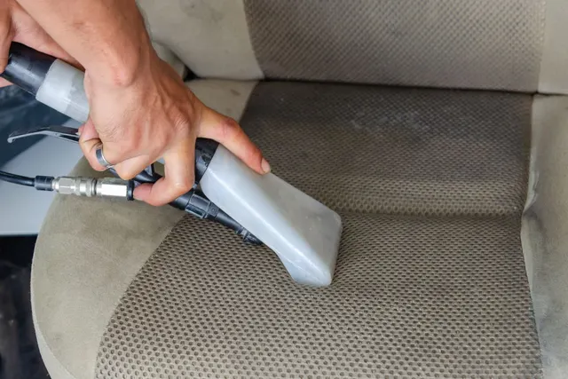 Extração profissional removendo a sujeira impregnada do banco de tecido de um carro